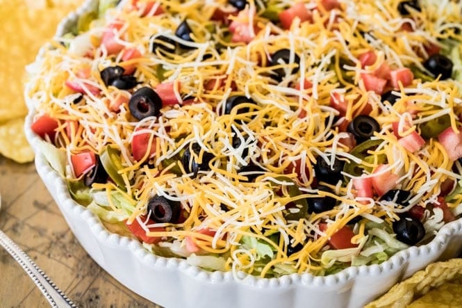 The BEST, easiest Taco Dip! This is so easy to make and so good! #tacodip #recipe #dip #cookout #summerfood Taco Dip in a serving dish