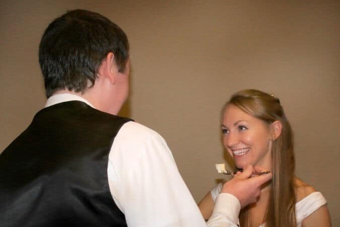 groom feeding bride slice of cake
