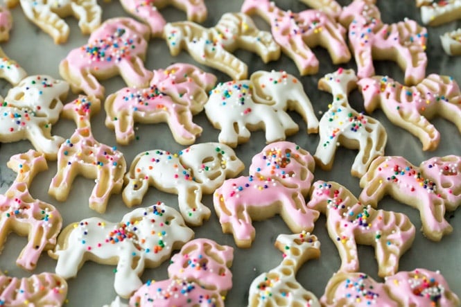 How to make adorable FROSTED ANIMAL COOKIES! Simple and sweet, no chilling required! Pink and white frosted animal cookies on marble