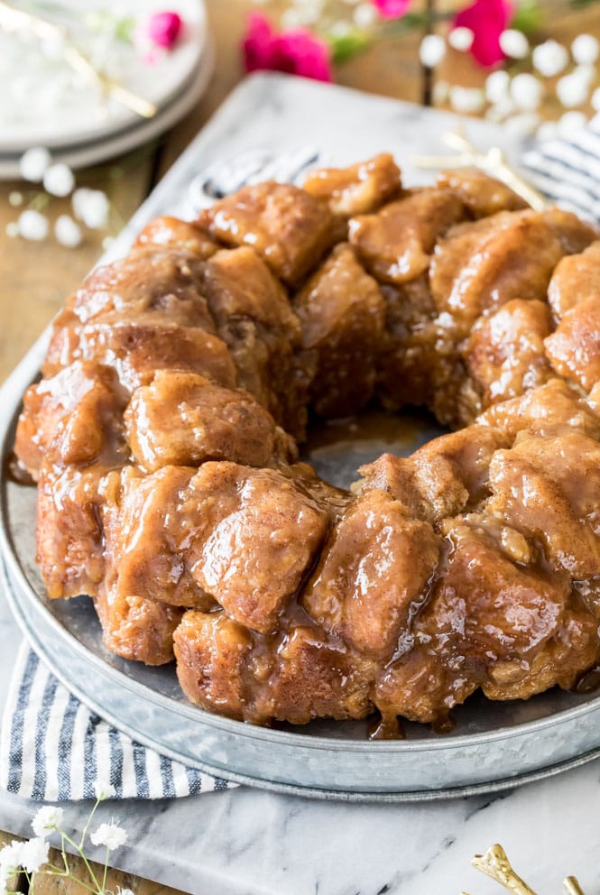 THE BEST Monkey Bread recipe! This homemade breakfast recipe is made completely from scratch, no yeast required! #monkeybread #breakfastrecipe #sugarspunrun Glazed monkey bread on metal platter