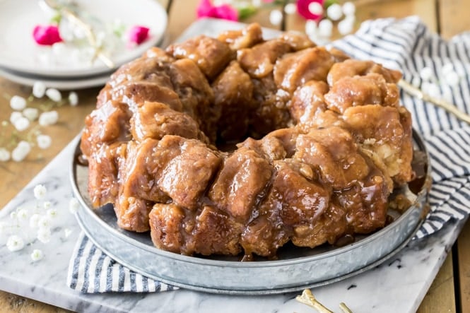 THE BEST Monkey Bread recipe! This homemade breakfast recipe is made completely from scratch, no yeast required! #monkeybread #breakfastrecipe #sugarspunrun Monkey Bread cooling on cake platter