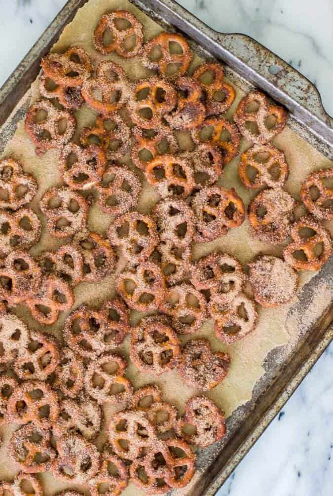 Snappy, chocolate-y, tossed in cinnamon, sugar, and butter, these CANDIED PRETZELS make a great and easy party snack! #partyfood #easyrecipe #sugarspunrun candied pretzels going into the oven to bake