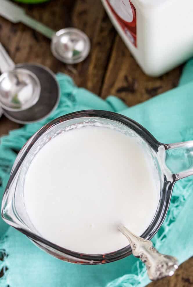 Overhead of milk and lemon juice mixture in measuring cup