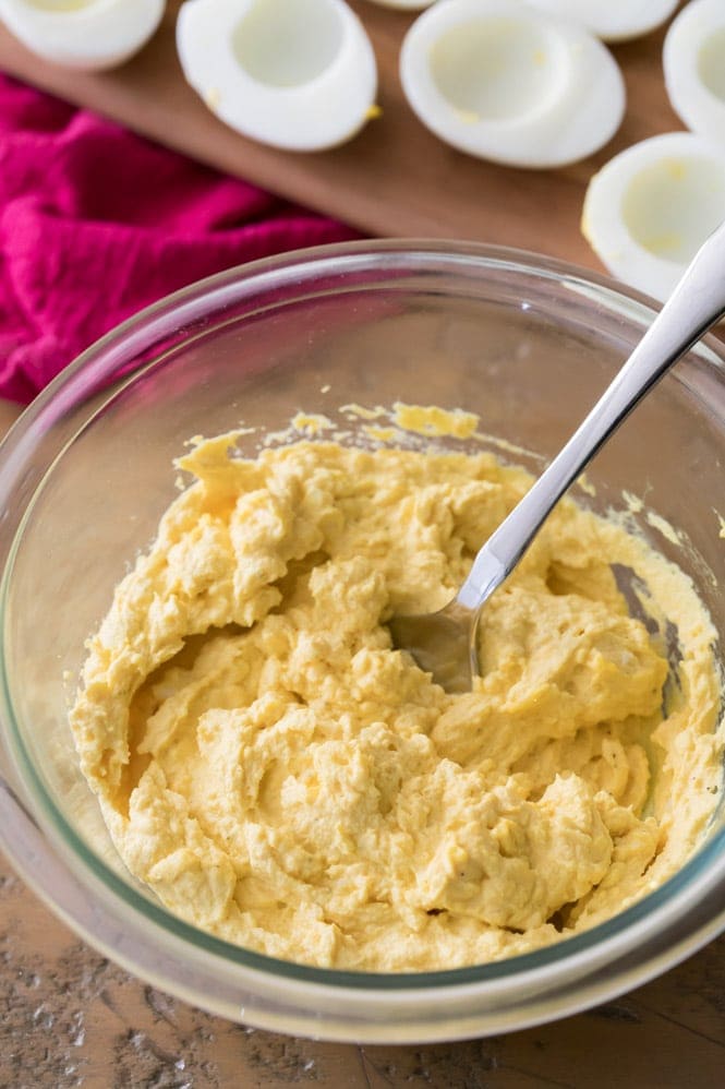 How to make the best deviled eggs recipe! These deviled eggs use a secret ingredient and they are so good! #deviledeggs #easterrecipe How to Make Deviled Eggs: Mashing the filling with a fork