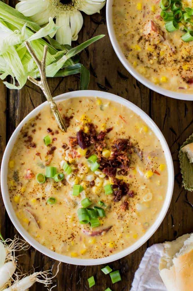 Overhead of corn chowder in bowl with toppings