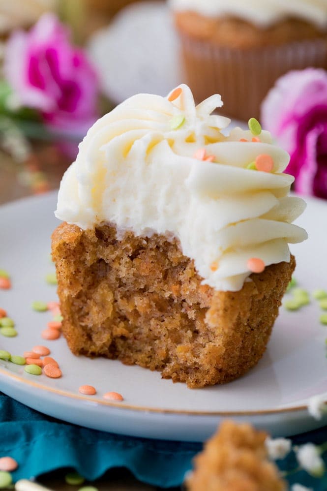 The very BEST Carrot Cake Cupcakes with cream cheese frosting! Half of a carrot cake cupcake, showing the moist vibrant orange center