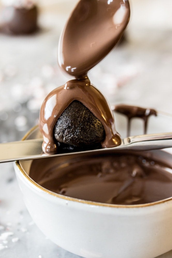 Just 4 ingredients for these easy OREO BALLS! An easy party dessert, ready in under 30 minutes! #sugarspunrun #oreoballs #oreotruffles #partyfood Coating oreo balls with melted chocolate
