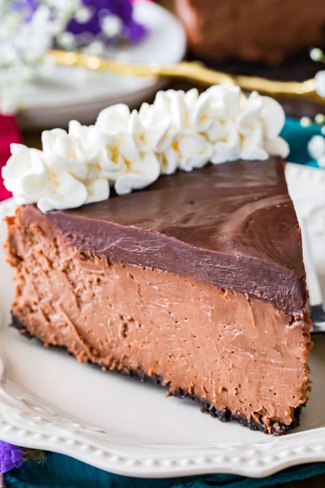 The BEST Chocolate Cheesecake -- no water bath required! #cheesecake #chocolate #dessert #recipe A slice of chocolate cheesecake topped with chocolate ganache and whipped cream