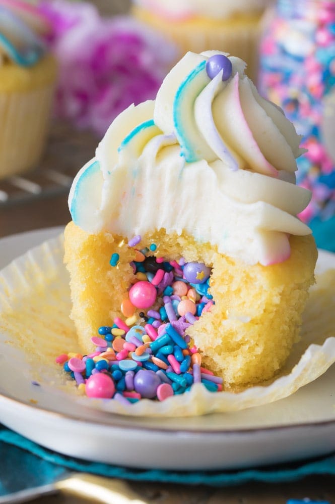 How to Make Pinata Cupcakes! These are so simple to make but they look SO COOL! Add your favorite filling and top with a colorfully swirled frosting! Vanilla Pinata Cupcake Filled with sprinkles