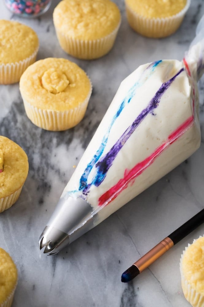 How to pipe pretty swirled frosting on your cupcakes A piping bag that's been painted with food coloring stripes to make a swirled frosting
