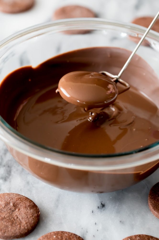 How to make your own copycat Thin Mint cookies at home A chocolate cookie that's just been dipped in a bowl of melted chocolate and lifted out for the excess chocolate to drip off