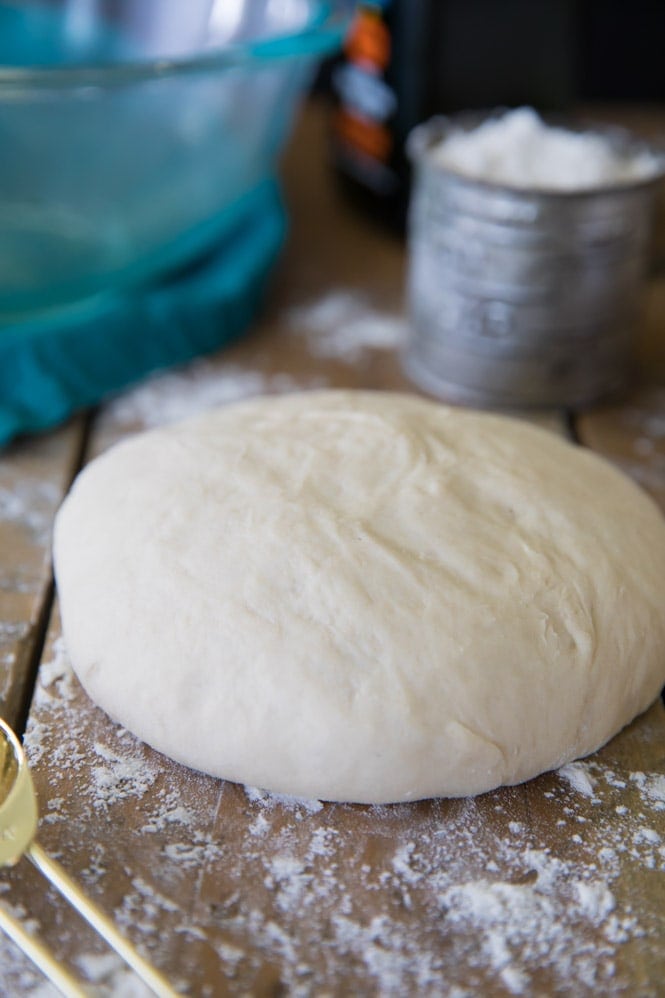 How to make the BEST pizza dough recipe. 10 minutes to prep and 30 minutes to rise for a this foolproof pizza dough! #pizzadough #pizza #baking #dinnerrecipe #easydinner Pizza dough formed into a ball before rising