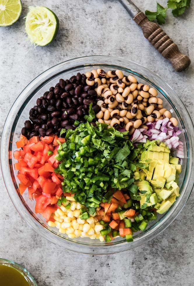 How to make TEXAS CAVIAR! Have you tried this summertime staple!? So good, everyone is going to want the recipe! #texascaviar #summersalad #dip #diprecipe #cookoutfood #partyfood #summerfood Texas caviar ingredients in a bowl
