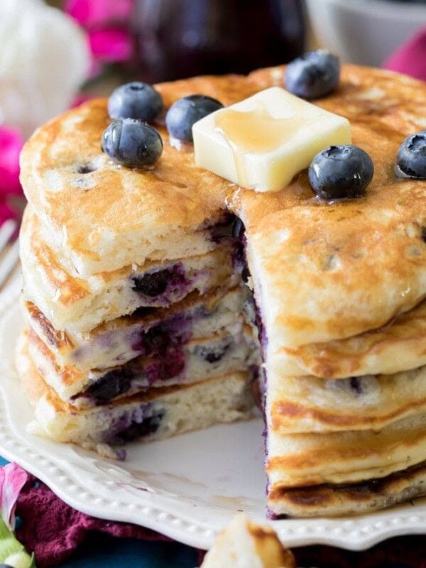 Stack of blueberry pancakes topped with pat of butter