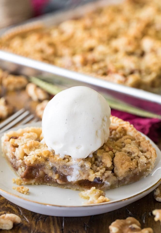 Have you ever made a slab pie? This APPLE SLAB PIE is so simple to make and to serve! #applepie #fallrecipe #fallbaking #applerecipe #Thanksgivingrecipe #thanksgiving Slice of apple slab pie with ice cream