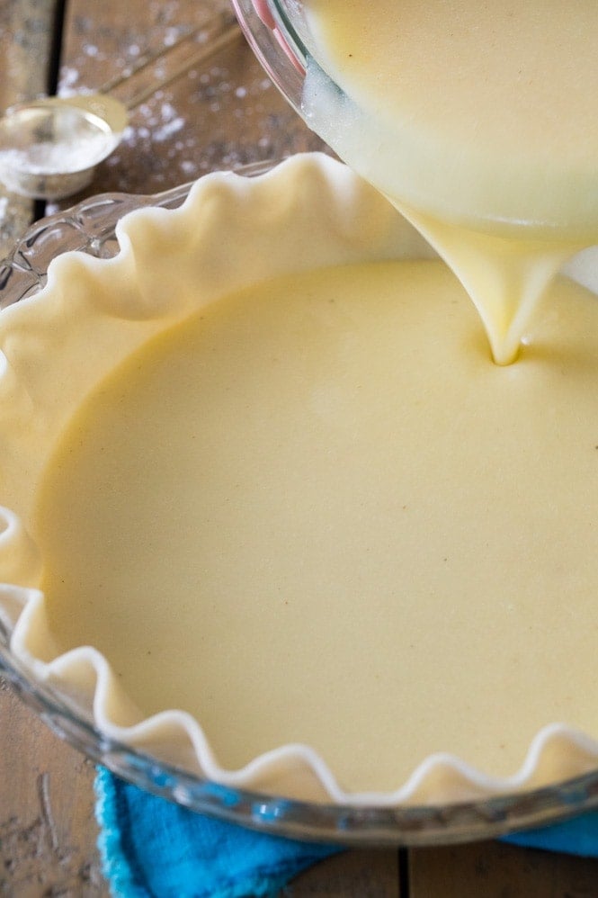 How to make BUTTERMILK PIE! Easy and an old-fashioned classic. #pierecipe #thanksgivingpie Pouring buttermilk pie filling into pie shell