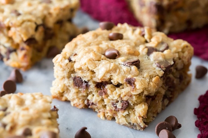 I love these OATMEAL COOKIE BARS! Hearty and packed with chocolate, these are so good! #cookiebar #easyrecipe #barcookie Oatmeal cookie bar square