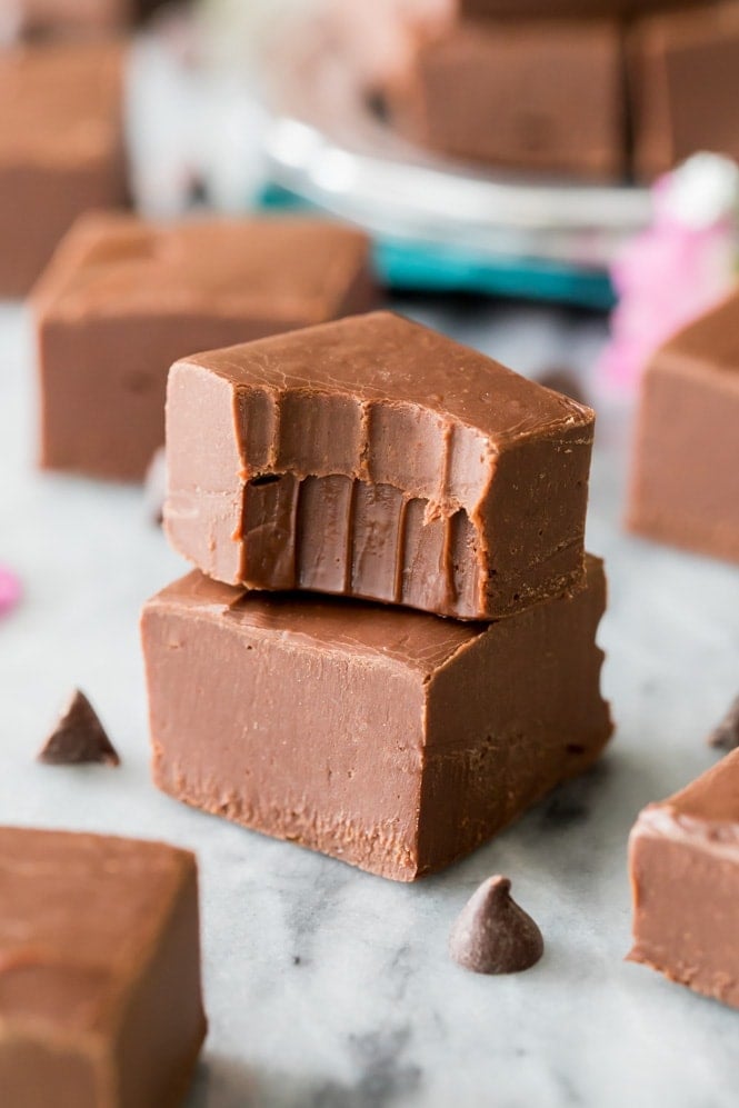 The best EASY Fudge Recipe! It makes the best fudge! #candyrecipe #fudgerecipe Stack of chocolate fudge with bite