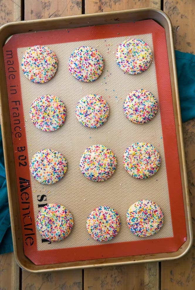 Fun, colorful, SPRINKLE COOKIES! Buttery chewy cookies encased in a colorful sprinkle shell! #cookierecipe #bestcookies Sprinkle cookies on baking pan after baking