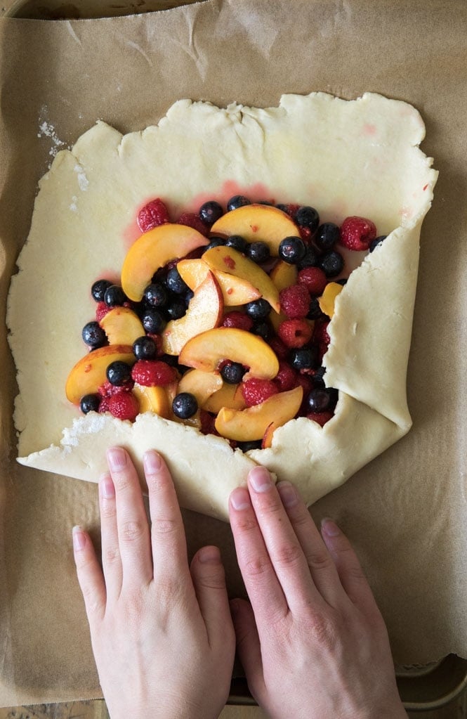 How to make a simple fruit galette recipe! Galettes are easier to make than fruit pies, but every bit as tasty. #summerrecipe #easypierecipe #sugarspunrun #easyaspie How to prepare fruit galette: folding over crust