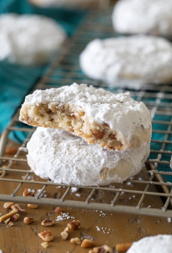 PECAN SANDIES are a simple cookie recipe any time of the year! No chilling and just a few ingredients! #cookierecipe #christmascookie #pecansandies #sugarspunrun Two pecan sandies on cooling rack, one showing buttery interior