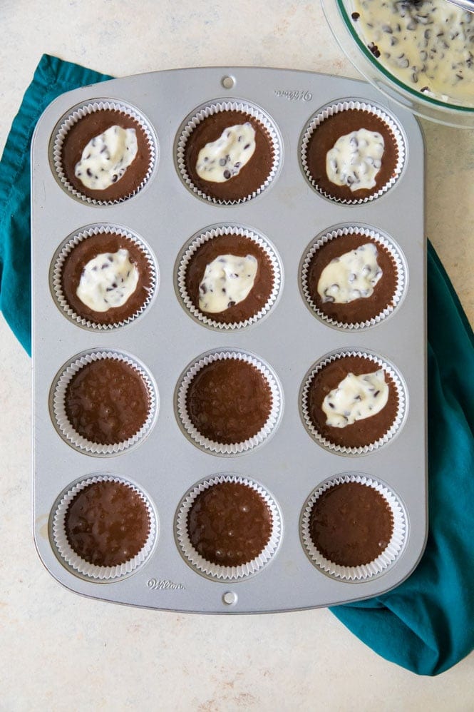 How to make classic BLACK BOTTOM CUPCAKES! Fudgy chocolate bottoms and rich cheesecake centers! So easy and so good! #chocolatecupcakes #blackbottomcupcakes #sugarspunrun Adding cheesecake batter on top of cupcake batter to make black bottoms
