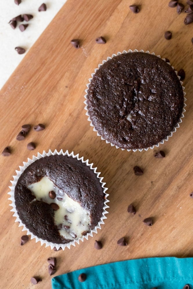 How to make classic BLACK BOTTOM CUPCAKES! Fudgy chocolate bottoms and rich cheesecake centers! So easy and so good! #chocolatecupcakes #blackbottomcupcakes #sugarspunrun A black bottom cupcake that has been overfilled (top) and a black bottom cupcake that has been filled properly (below)