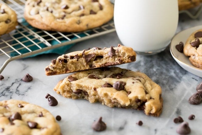 How to make GIANT Chocolate Chip Cookies! These have soft and chewy centers and crisp edges! #chocolatechipcookies #cookierecipe #sugarspunrun Big chocolate chip cookie broken in half with halves stacked on top of each other