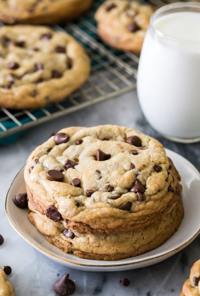 How to make GIANT Chocolate Chip Cookies! These have soft and chewy centers and crisp edges! #chocolatechipcookies #cookierecipe #sugarspunrun two giant chocolate chip cookies on a plate