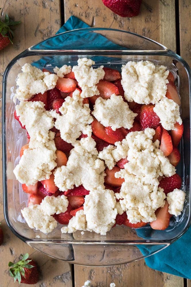 How to make a sweet and simple STRAWBERRY COBBLER! Easy and made completely from scratch, this recipe is a great way to use up summertime berries! #strawberryrecipe #cobblerrecipe #sugarspunrun #summerbaking Strawberry cobbler in glass dish before going in oven