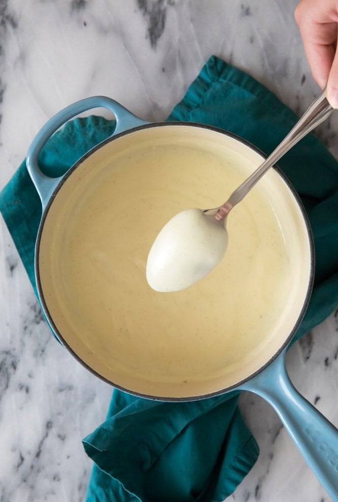 HOMEMADE VANILLA PUDDING! So easy to make with ingredients you already have on hand, no gelatin, no fancy odd ingredients! This is a great easy pudding recipe! #pudding #puddingrecipe #sugarspunrun Making vanilla pudding: testing consistency on the back of a spoon