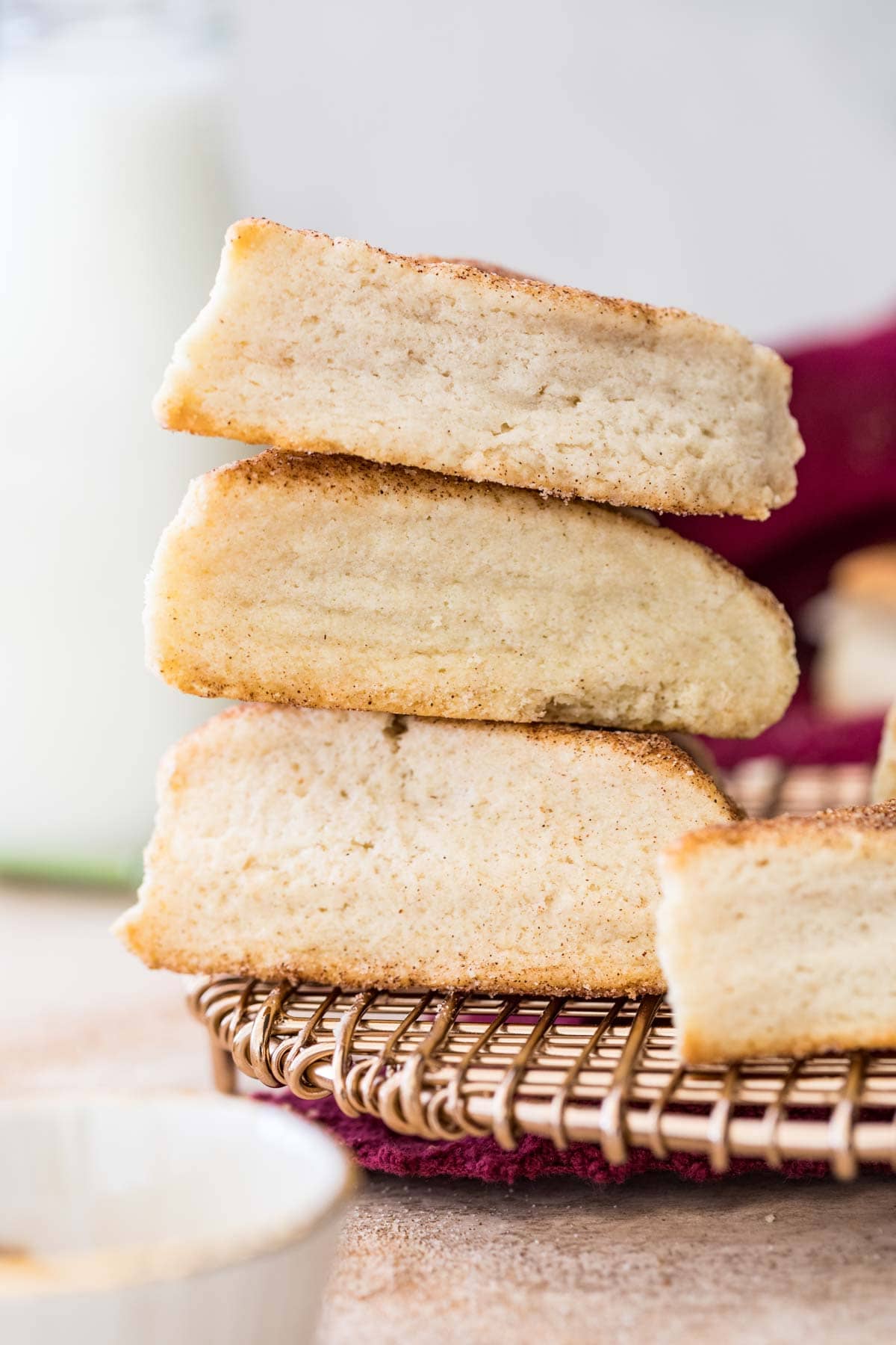Side view of three stacked snickerdoodle scones on gold metal cooling rack