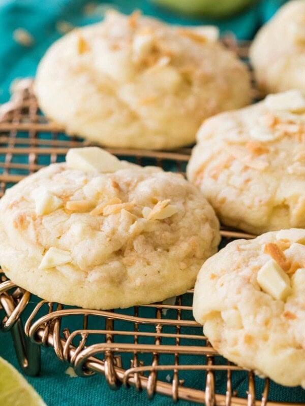 Island cookies topped with coconut and white chocolate chunks resting on a metal cooling rack