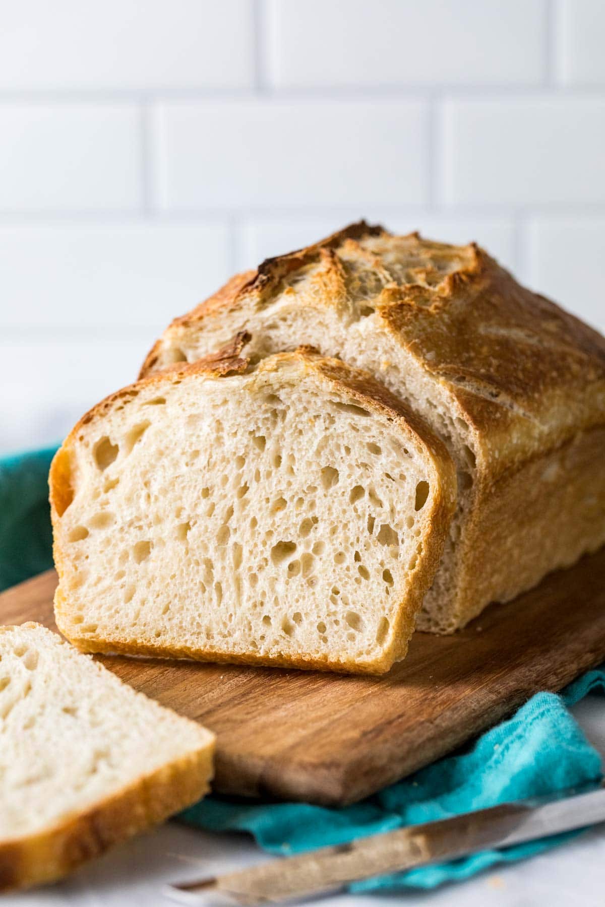 Photo of the bread from my sourdough bread recipe showing a lof with a slice resting against it.