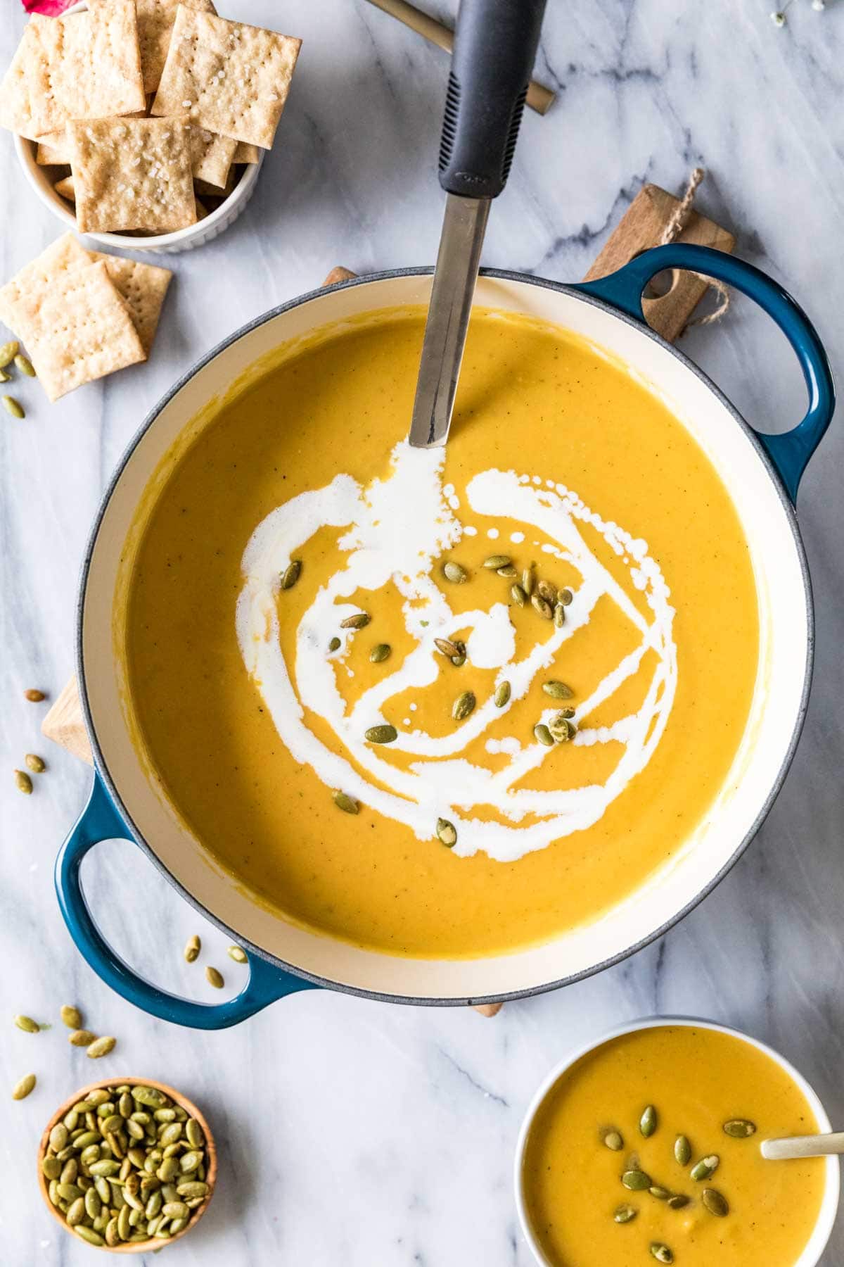 Overhead view of squash soup with coconut milk drizzled on top.