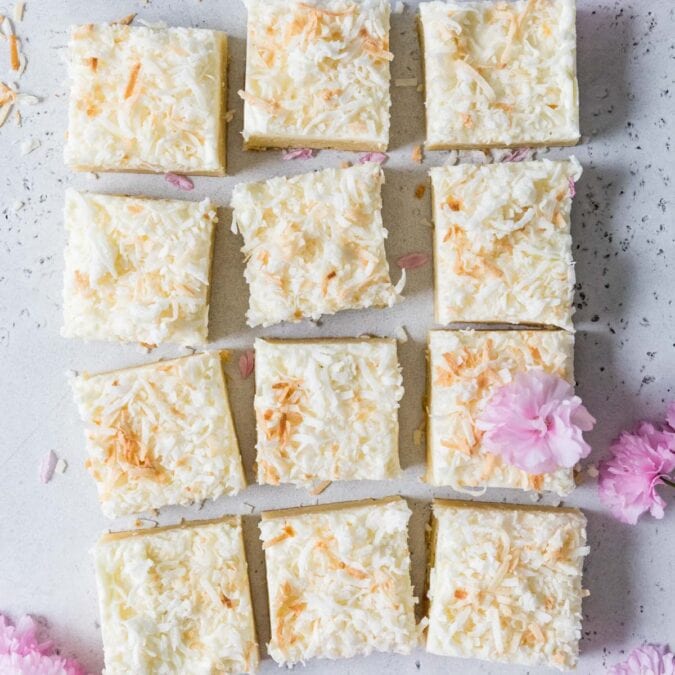 Overhead view of frosted coconut cream bars topped with toasted coconut.