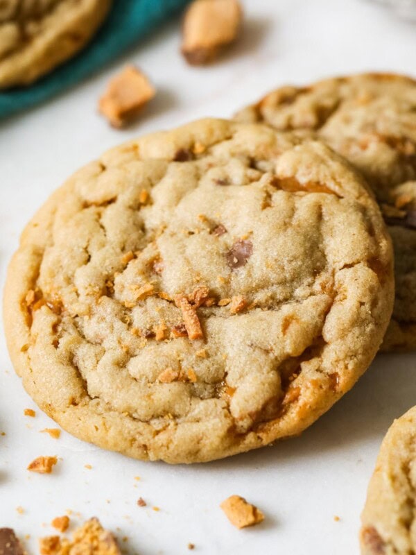 Two butterfinger cookies surrounded by crushed up butterfinger pieces.