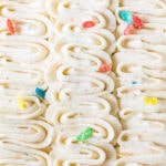 Piped ribbons of fruity pebbles frosting with fruity pebbles scattered on top.