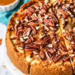 Turtle cheesecake with one slice cut but not removed.