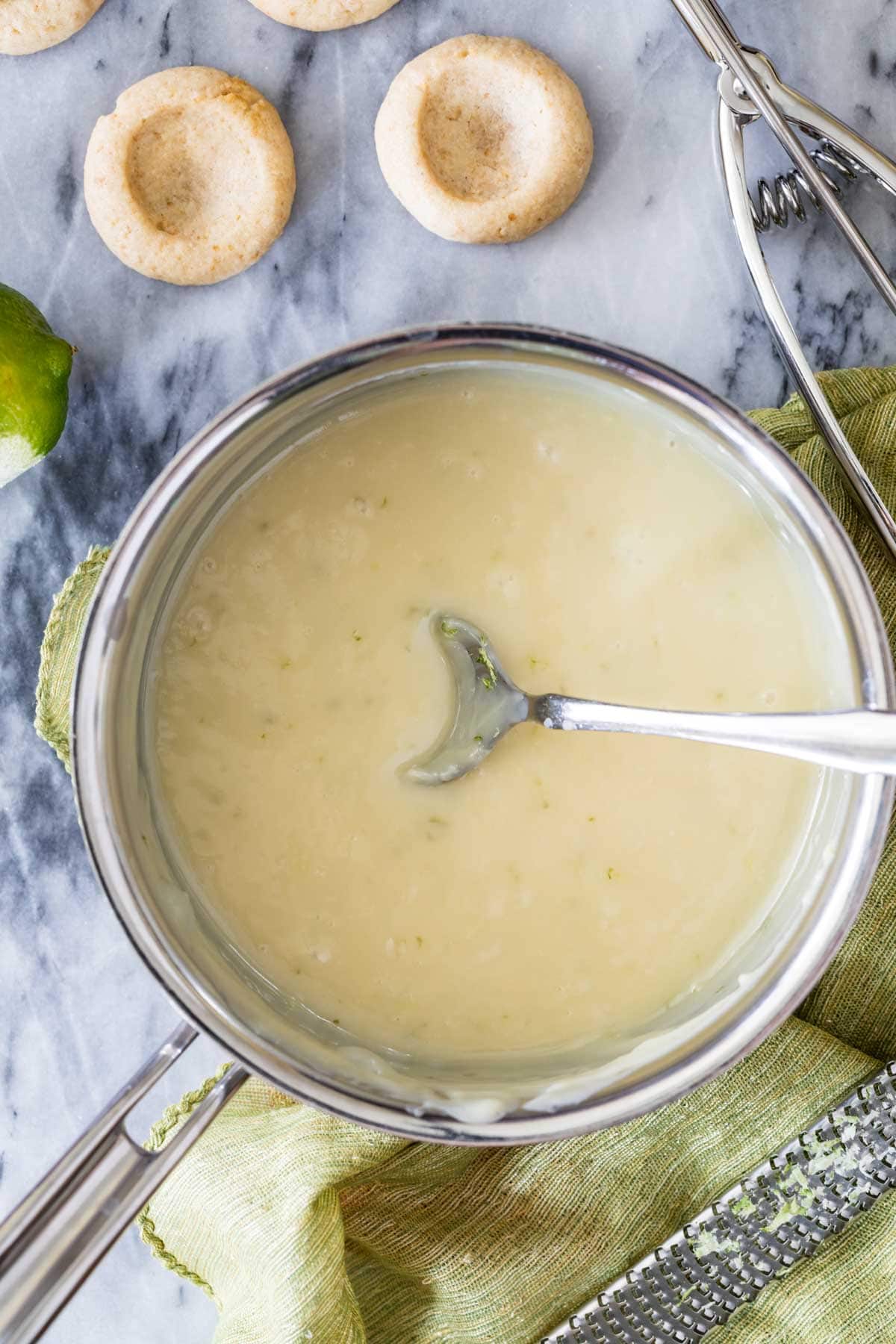Overhead view of a key lime pie filling being prepared for thumbprint cookies.