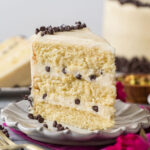 Slice of cannoli cake standing on a white plate.