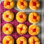 Overhead view of pineapple upside down cupcakes on a cooling rack.