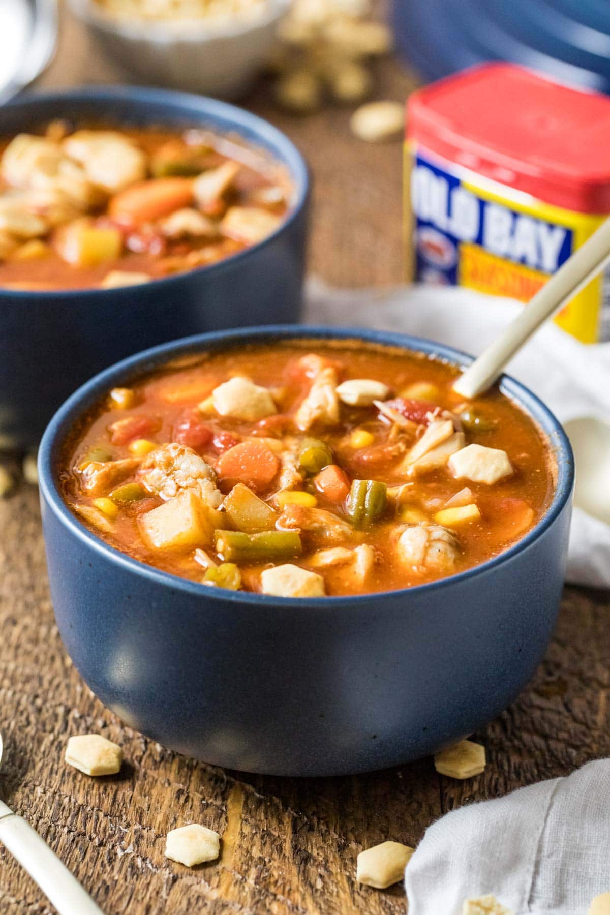 Blue bowl of maryland crab soup made with a tomato base, lump crab meat, old bay, and more.