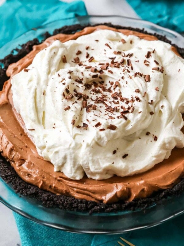 Mississippi mud pie topped with a thick layer of whipped cream and chocolate shavings.
