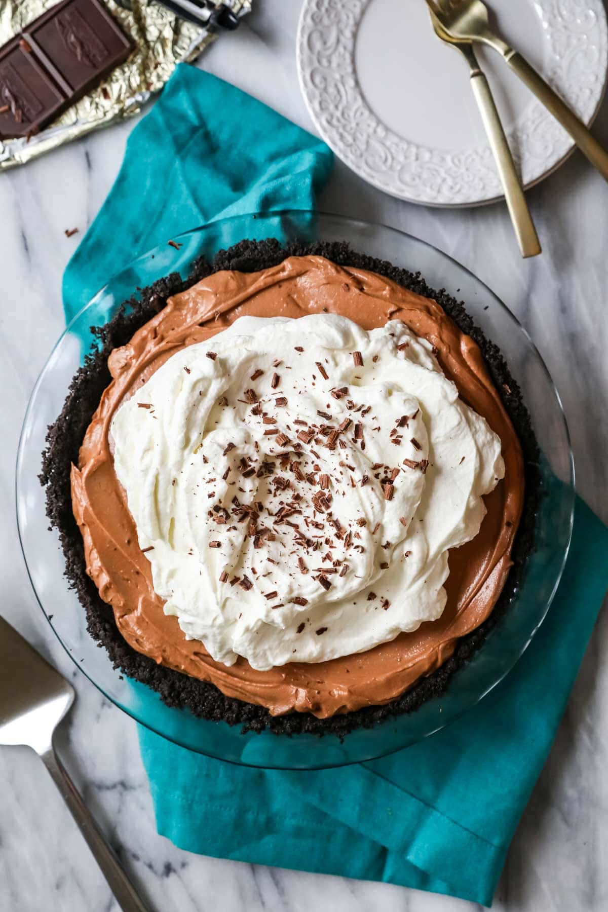 Overhead view of a chocolate based no-bake pie topped with whipped cream and chocolate shavings.
