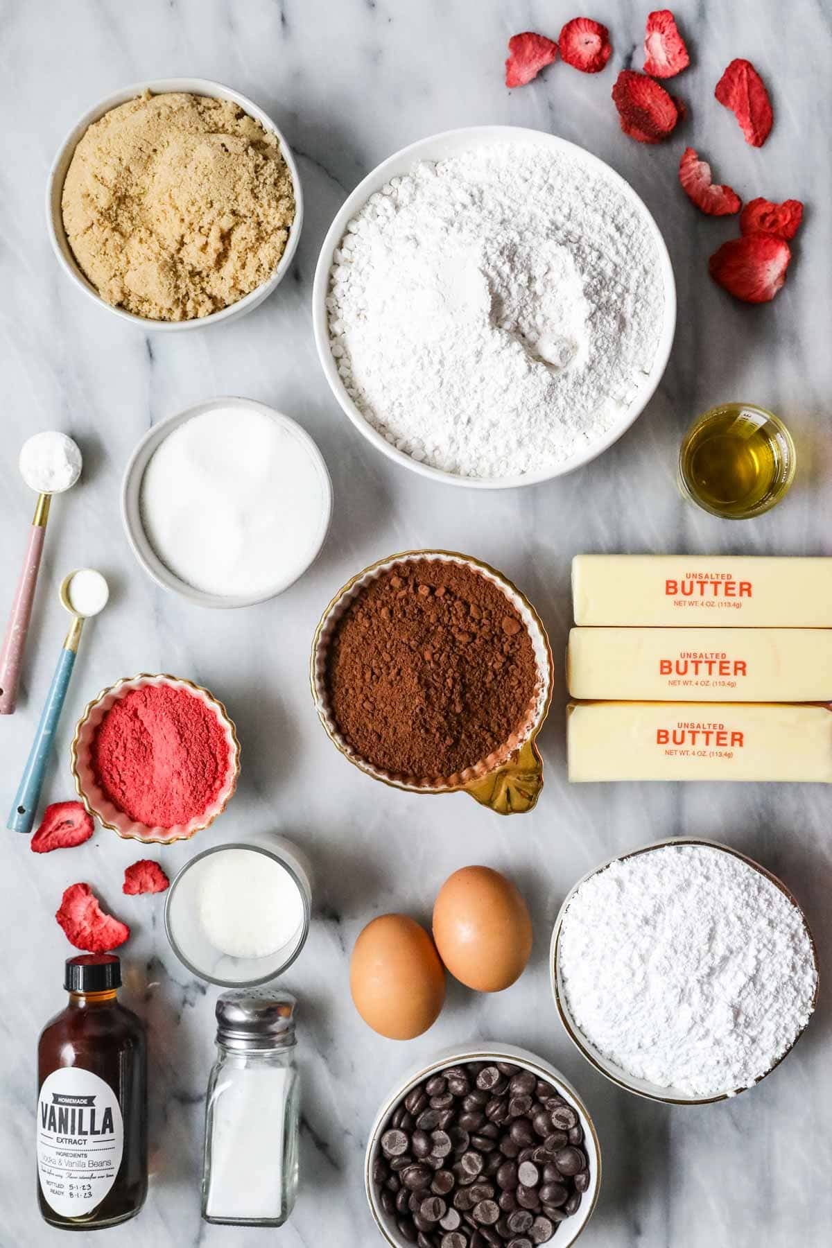 Overhead view of ingredients including freeze fried strawberries, cocoa powder, chocolate chips, and more.