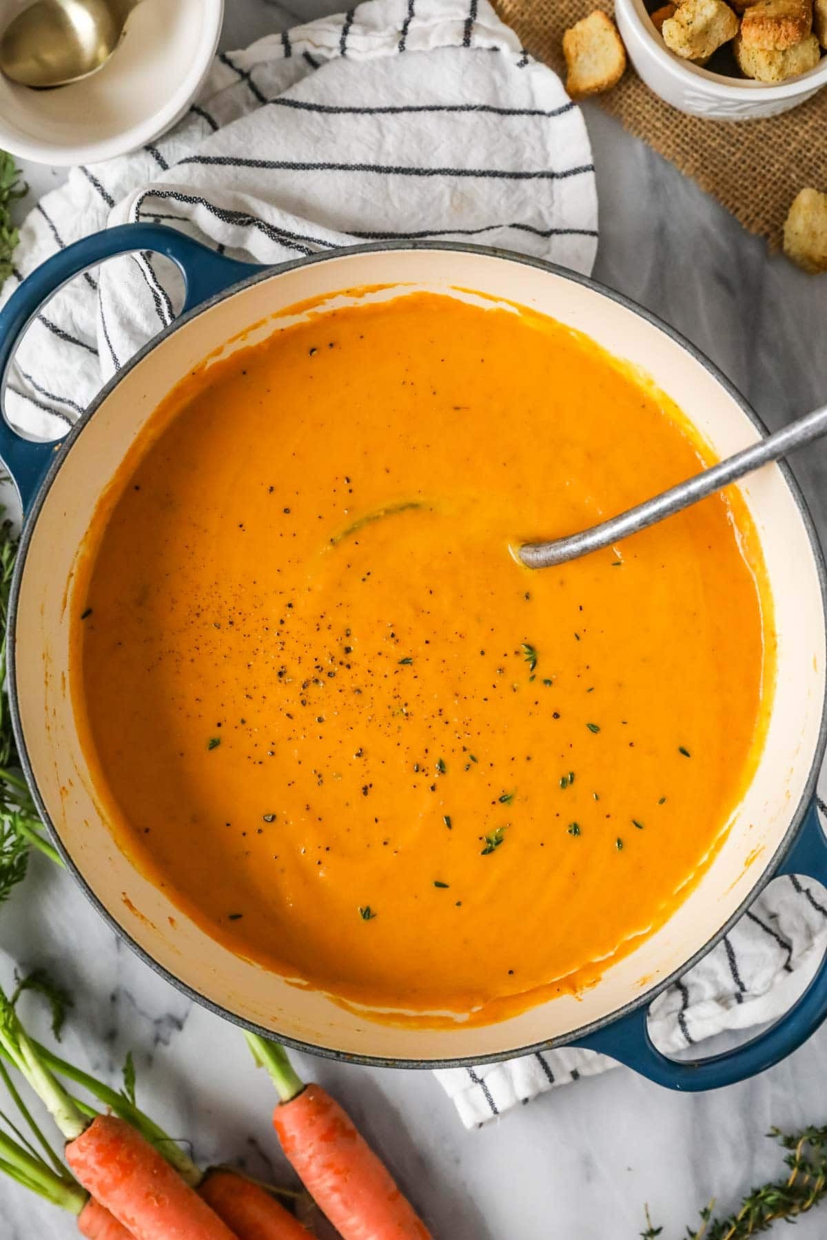 Overhead view of a pot of roasted carrot soup.