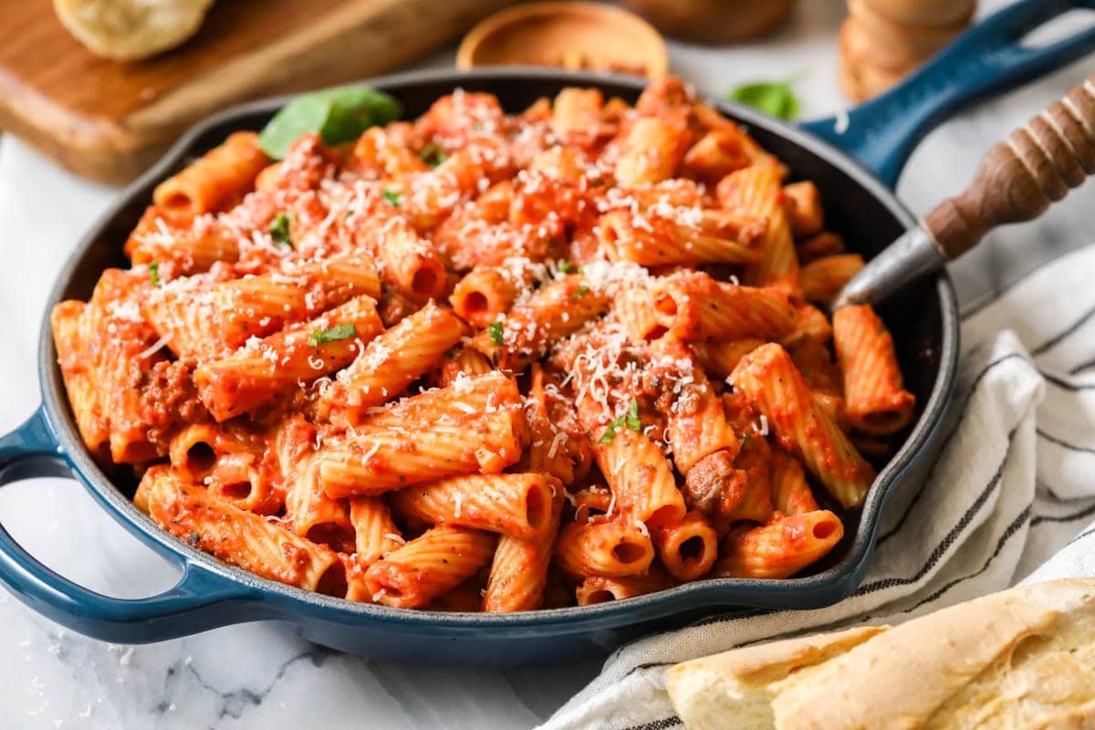 Skillet of homemade rigatoni topped with freshly grated parmesan cheese.