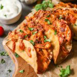 Crispy chicken tacos on a wood cutting board.