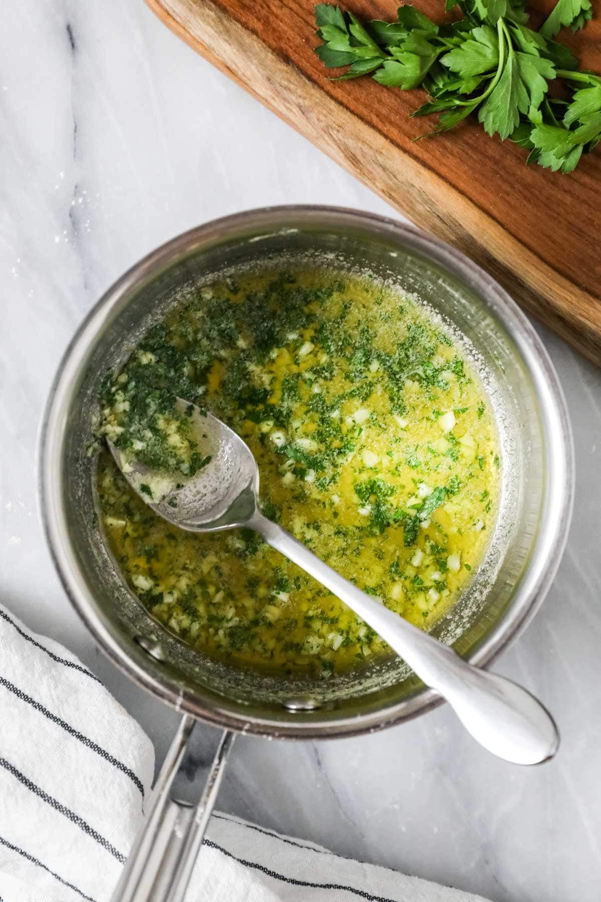 Overhead view of a pot of garlic butter.
